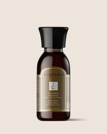 Emulsión corporal cítrica de ALQVIMIA: frasco oscuro con etiqueta dorada, sobre fondo beige.