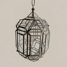 Farol colgante de paneles transparentes, estructura geométrica oscura y cadena.
