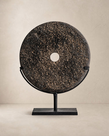 Figura decorativa de piedra oscura y hierro negro de Vical sobre fondo topo claro