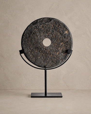 Figura decorativa Vical Seoane mediana de piedra oscura y hierro negro sobre fondo topo claro