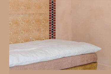 Friso Vertebra Sienne de papel de arroz en terracota y negro · 9 tiras de Le Monde Sauvage, colocado en vertical junto a una cama