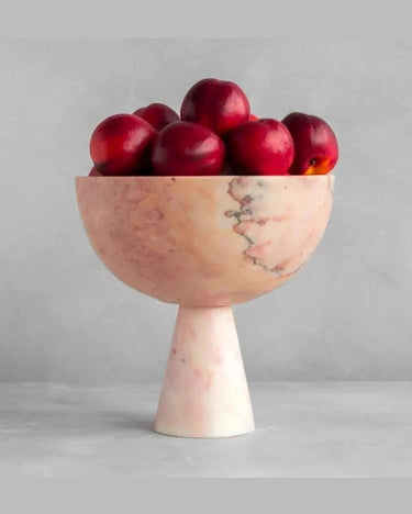 Frutero rosa de pie alto con fruta roja