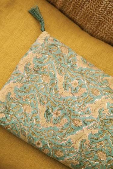 Detalle del estampado de animales y plantas y del pompón verde de la funda Caravane Letho
