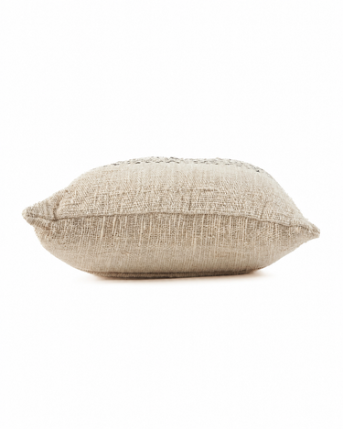 Funda de cojín de algodón natural con pespuntes negros, vista de perfil con volumen de cojín