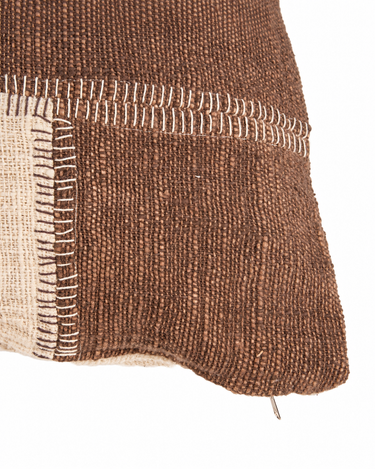 Funda de cojín patchwork de algodón marrón y natural, detalle de una esquina y las costuras