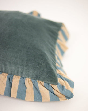 Blue ruffled cushion cover by Olsson & Jensen on a sofa