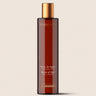 Gel de ducha de incienso y mirra de ALQVIMIA: envase ámbar alargado con tapón dorado, sobre fondo beige.