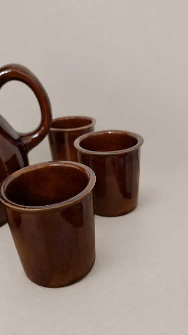 Detalle de los vasos marrones y del asa de la jarra.