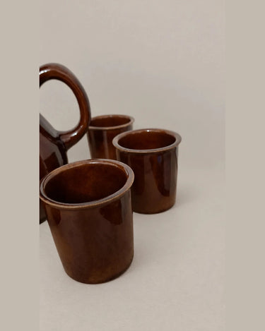 Detalle de los vasos marrones y del asa de la jarra.
