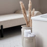 Jarrón de gres gris en una composición de materiales naturales