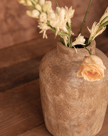 Jarrón de terracota en color crema de Bazar Bizar, detalle con un ramo de flores