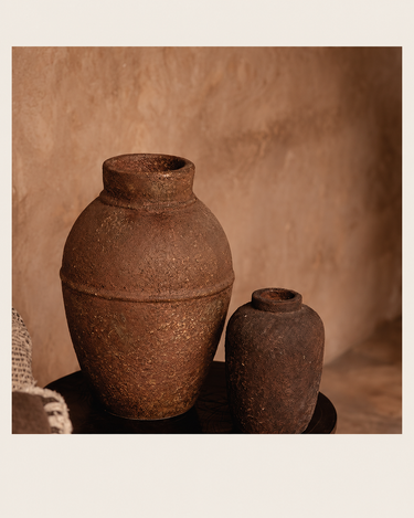 Jarrón de terracota de silueta alargada, junto a un jarrón más pequeño