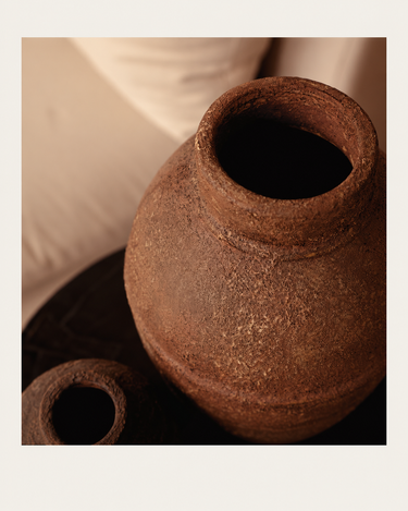 Jarrón de terracota de silueta alargada, vista superior de la boca en una composición de interior
