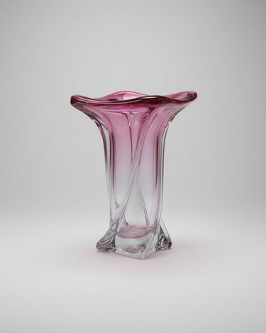 Jarrón vintage de vidrio rosa con boca ondulada, aristas curvas y base transparente cuadrada