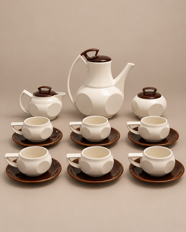 Juego de café facetado en cerámica blanca y marrón, vista frontal sobre fondo topo claro
