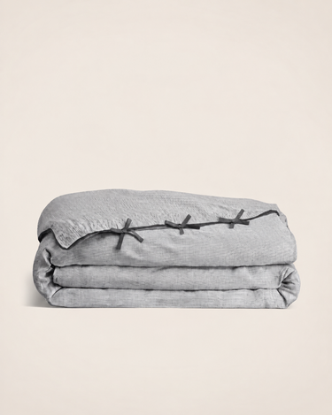 Juego de cama Caravane, detalle de la funda nórdica gris doblada y sus lazos