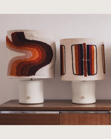 Lámpara de mesa de cerámica con pantalla de bandas verticales de âme philo, junto a una lámpara con dibujo ondulado