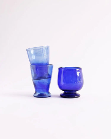 Tres vasos azules apilados junto a una copa azul