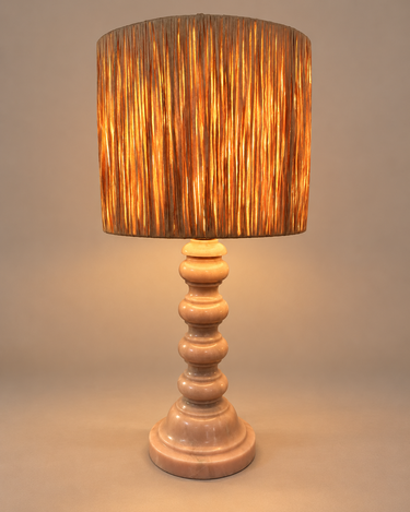 Lámpara de mesa de Matuta Home encendida, con luz cálida a través de la pantalla de fibra natural