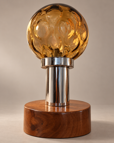Detalle del globo ámbar, cuello cromado y base de madera de una lámpara vintage
