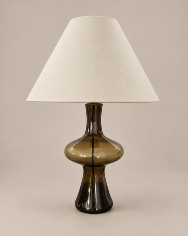 Lámpara de mesa vintage de vidrio ahumado ámbar con pantalla crema, apagada sobre fondo topo claro