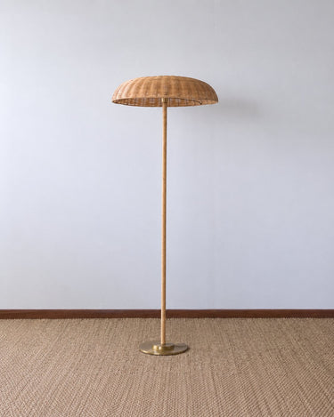 Lámpara de pie de Mahe Homeware con pantalla de ratán natural y base dorada, apagada.