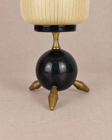 Detalle de base esférica negra y patas de latón de lámpara de mesa vintage