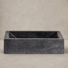 Lavabo rectangular de piedra negra de Vical sobre fondo topo claro