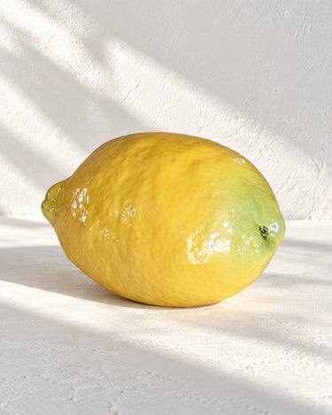 Limón de cerámica realista artesanal amarillo de Ánfora sobre cal blanca
