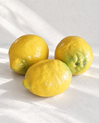 Limones amarillos de cerámica con textura irregular y matices verdes