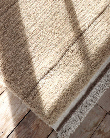 Alfombra de pasillo lavable de lana beige con flecos en recibidor o zona de paso natural