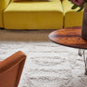 Alfombra Bahari beige colocada junto a una cama
