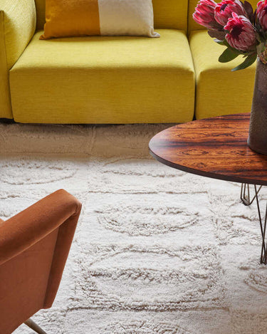 Alfombra Bahari beige colocada junto a una cama