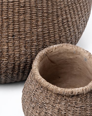 Macetero de hormigón marrón con textura trenzada, detalle de la boca y la textura junto a otro macetero