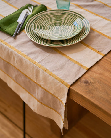 Mantel de rayas con platos sobre una mesa de madera de Caravane