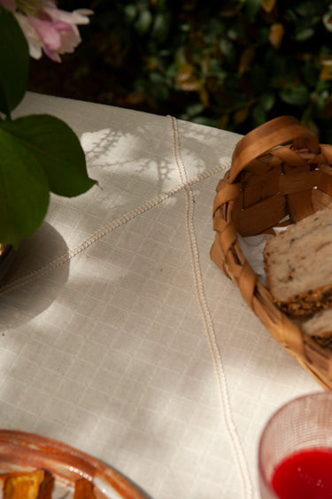 Mantel de algodón natural con cinta ondulada de Bicla, detalle del tejido sobre una mesa puesta