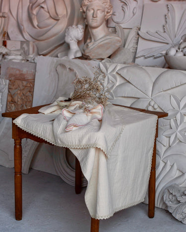Mantel natural de algodón con puntilla sobre una mesa