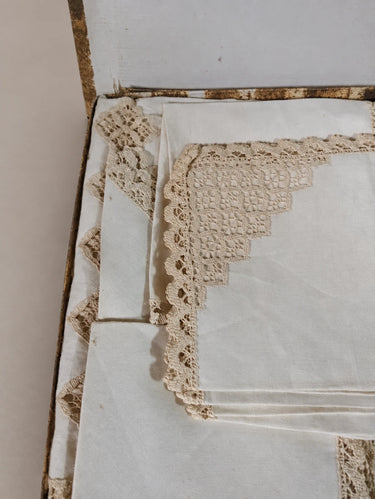 Piezas plegadas de mantelería clara con bordes calados.