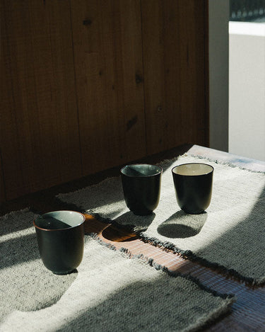 Manteles individuales de algodón natural y gris tejidos a mano sobre una mesa