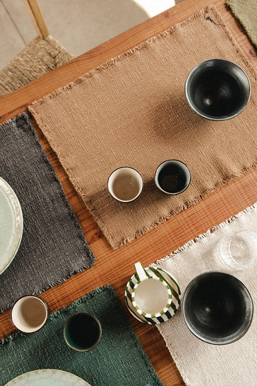 Set de manteles individuales de algodón ocre en ambiente de comedor