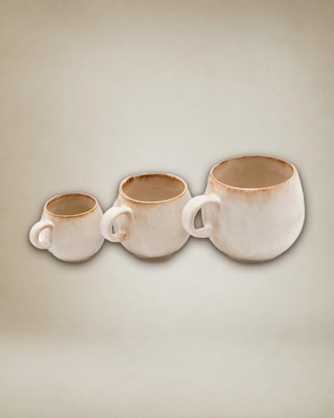 Set de mugs blancos de cerámica en mesa