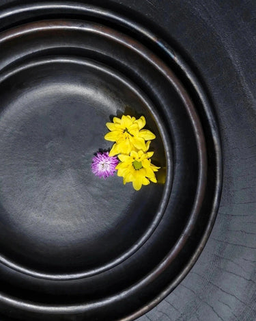 Small black ceramic plate by Bazar Bizar, side view
