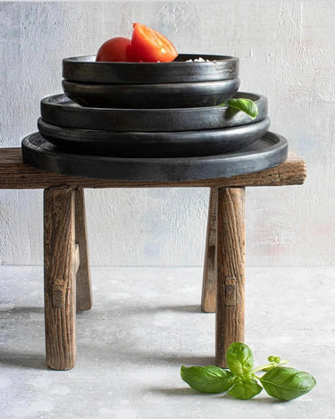 Small black ceramic plate by Bazar Bizar in a styled setting