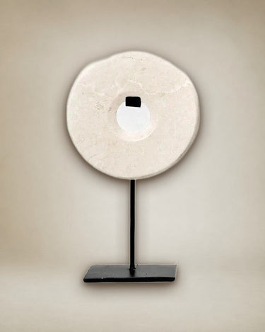 Objeto decorativo de mármol blanco sobre soporte