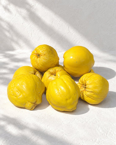 Membrillo de cerámica realista artesanal amarillo de Ánfora, en un grupo de piezas