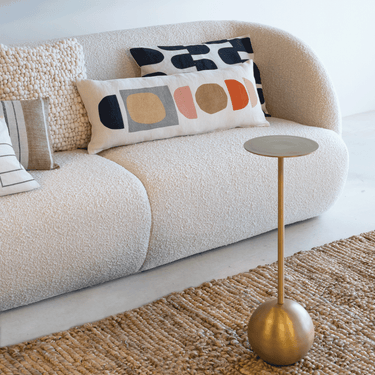 Mesa auxiliar alta de aluminio dorado: como apoyo junto a un sofá de bouclé