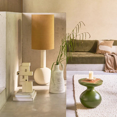 Mesa auxiliar de hierro verde: junto a un sofá con textiles naturales