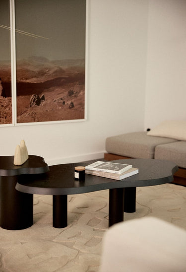 relación entre material y forma de mesa auxiliar de madera lasurada negra de Gabrielle Paris