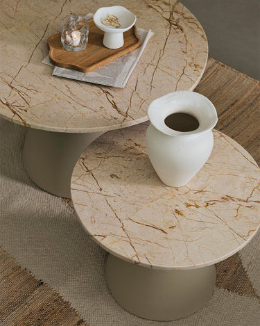 Mesa auxiliar de mármol beige junto a un sofá