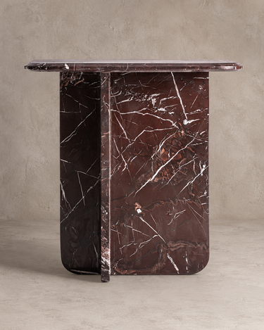 Mesa auxiliar de mármol burdeos brillo de Vical ante pared texturizada topo claro